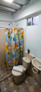 a bathroom with a toilet and a shower curtain at CasaLuna Tayrona in Santa Marta