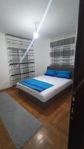 a bedroom with a bed with blue pillows at Martha`s place Drač in Podgorica