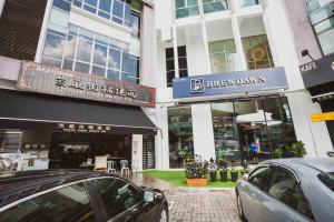 a city street with cars parked in front of buildings at Hashtag.Capsule.Hostel in Johor Bahru