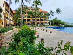 a resort with a swimming pool and palm trees at Hon Rom Central Beach Resort in Mui Ne