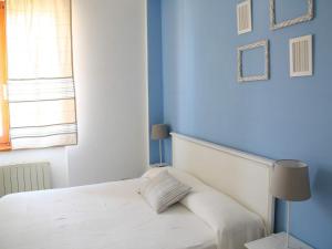 a bedroom with a white bed with a blue wall at Cristina B&B in Sassoferrato