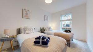 1 dormitorio con 2 camas y ventana en Luxury 2 Bed Apartment with Parking near London, en Swanscombe