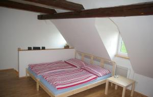 Una cama con una manta a rayas en una habitación en Apartmány Růžová, en Růžová