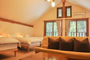 uma sala de estar com duas camas e um sofá em Lodge Denbey em Nozawa Onsen