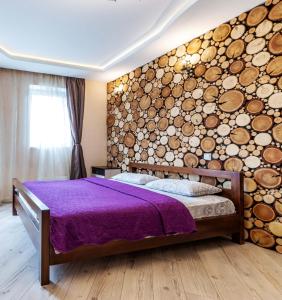 エカテリンブルクにあるЮмашева DreamHouse Апарт-отельの大きな丸太の壁が備わるベッドルーム