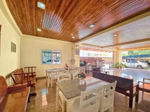 a dining room with a table and chairs at Jaroonsak Grand in Trang
