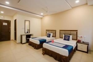 a hotel room with two beds and a mirror at Way Inns in Hyderabad