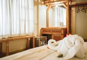 um quarto com uma cama com um espelho e uma toalha em Amed Cafe & Hotel Kebun Wayan em Amed