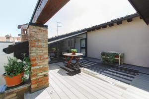 a wooden deck with a table on the side of a house at San Clemente in Crema