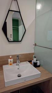 a bathroom with a white sink and a mirror at 胖蝸牛親子民宿 in Anping