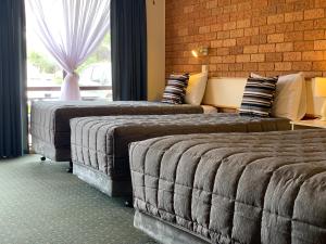 Habitación de hotel con 2 camas y ventana en Newell Motor Inn Narrandera, en Narrandera