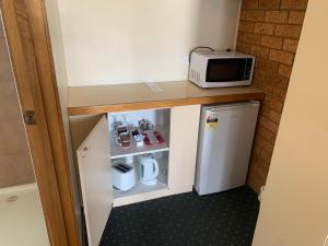 a microwave oven sitting on top of a kitchen counter at Newell Motor Inn Narrandera in Narrandera