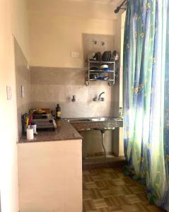 a small kitchen with a counter and a sink at Sarthak Home Stay, Beautiful Valley view of Mountain in Jagatsukh