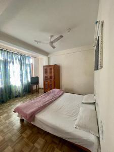 a bedroom with a large bed and a window at Sarthak Home Stay, Beautiful Valley view of Mountain in Jagatsukh
