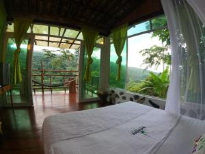 1 dormitorio con cama y ventanas grandes con vistas. en Alojamiento rural Bellavista Experiences, en Mocoa