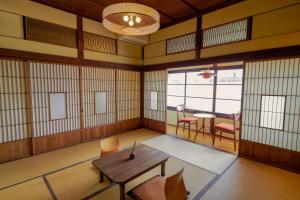a room with a table and chairs in a room at Ryokan Plum in Odawara