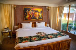 Kurja Resort Balsamand في جودبور: غرفة نوم بسرير مع لوحة على الحائط