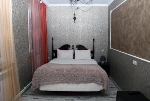 a bedroom with a large bed with white pillows at Hotel Kambuz in Sevan