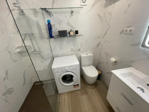 bagno bianco con servizi igienici e lavatrice. di Immodelpas Pessons a Pas de la Casa