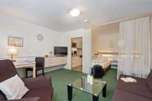 a hotel room with a couch and a table at Appartementhaus Bavaria in Bad Füssing