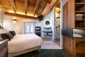 um quarto com uma cama grande e tectos em madeira em Wanderful Life Les Arcs refuge haut de gamme em Arc 1600