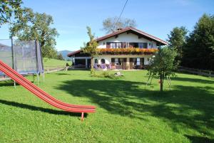 a house with a playground with a slide in the yard at Landhaus Vogler in Fischen