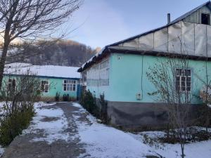 a blue and white building with snow on the ground at Guest house Shairkul in Kyzylunkyur