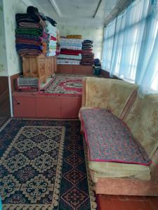 a room with a couch and lots of rugs at Guest house Shairkul in Kyzylunkyur +25 photos
