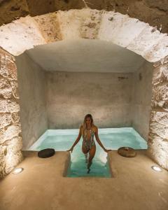 una mujer en un charco de agua en Doda Artisanal Cave Hotel - Adults Only -, en Nevşehir