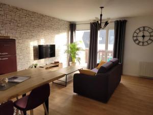 a living room with a couch and a wooden table at Appartement neuf style industriel *** proche de la mer in Roscoff