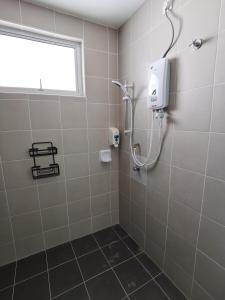 baño con cabina de ducha y ventana en My Homestay N43 (14 pax) @ Golden Hills Night Market en Tanah Rata