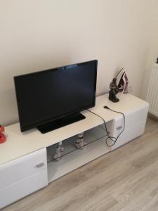 a flat screen tv sitting on top of a white entertainment center at Apartmani ANTEL 5 in Banja Koviljača