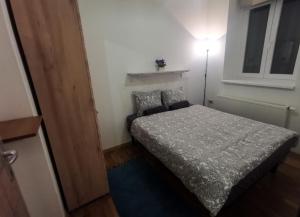 ein kleines Schlafzimmer mit einem Bett und einer Lampe in der Unterkunft Zagreb Creative Apartments APP 5 in Zagreb
