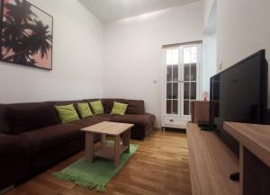 ein Wohnzimmer mit einem braunen Sofa und einem Tisch in der Unterkunft Zagreb Creative Apartments APP 5 in Zagreb