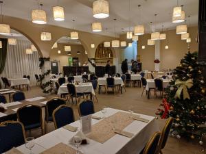 a dining room with tables and a christmas tree at Hotel Iri in Buşteni