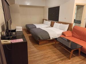 ein Hotelzimmer mit einem Bett und einem Sofa in der Unterkunft 九族飯店 臺東縣旅館004號 in Wenquan