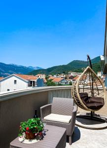 a balcony with a chair and a swing and a table at Mavalux apartments in Tivat