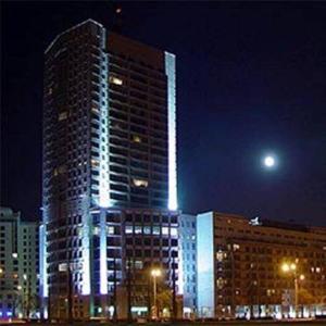 un edificio alto con luces encendidas por la noche en Babka Tower Suites Apartamenty - Pokoje, en Varsovia