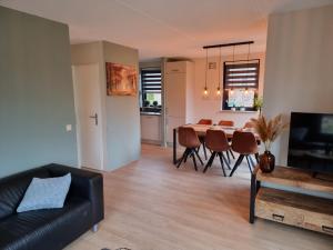 een woonkamer en eetkamer met een tafel en stoelen bij Vakantiewoning Maas en Waal 277 in Ewijk
