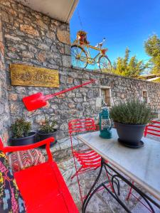 einen Tisch mit Stühlen und ein an der Wand hängendes Fahrrad in der Unterkunft "Orchomenos" Apartment of Levidi Arcadian Apartments in Leonidi