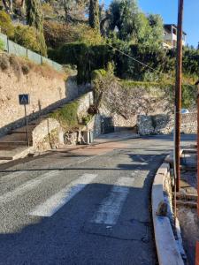 una calle vacía con un cartel en el costado de una colina en Soutariba, en Roquebrune-Cap-Martin