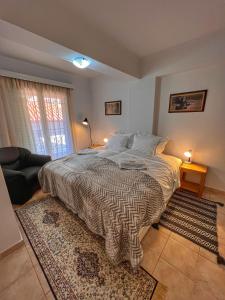 ein Schlafzimmer mit einem Bett und ein Wohnzimmer in der Unterkunft "Orchomenos" Apartment of Levidi Arcadian Apartments in Leonidi