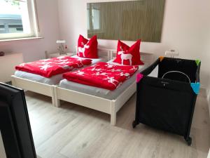 - 2 lits dans une chambre avec des oreillers rouges dans l'établissement Arche Noah Reilingen near Hockenheim and Walldorf, à Reilingen