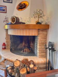a living room with a brick fireplace with logs at "Orchomenos" Apartment of Levidi Arcadian Apartments in Levidhion