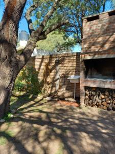 una chimenea de ladrillo junto a una pared de ladrillo con un árbol en Analina, en San Marcos Sierras
