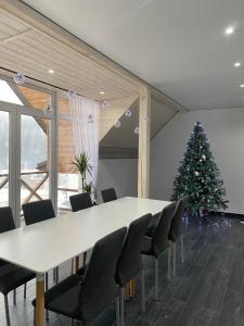 a conference room with a christmas tree and a table and chairs at Haya Villa in Bukovel