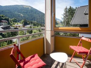 a balcony with two chairs and a view of a mountain at Appartement Dorfblick in Bad Kleinkirchheim