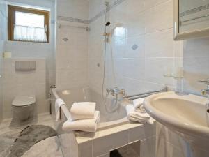 ein Badezimmer mit einer Badewanne, einem Waschbecken und einem WC in der Unterkunft Appartement Dorfblick in Bad Kleinkirchheim