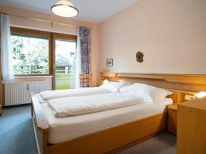 ein Schlafzimmer mit einem großen Bett und einem Fenster in der Unterkunft Appartement Dorfblick in Bad Kleinkirchheim