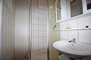 ein weißes Bad mit einem Waschbecken und einer Dusche in der Unterkunft Private Zimmervermietung in Wien